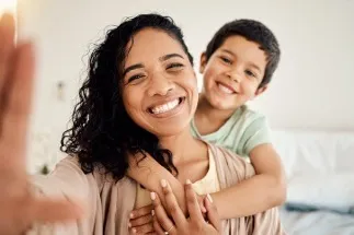 A smiling woman with a child, representing family and happiness.